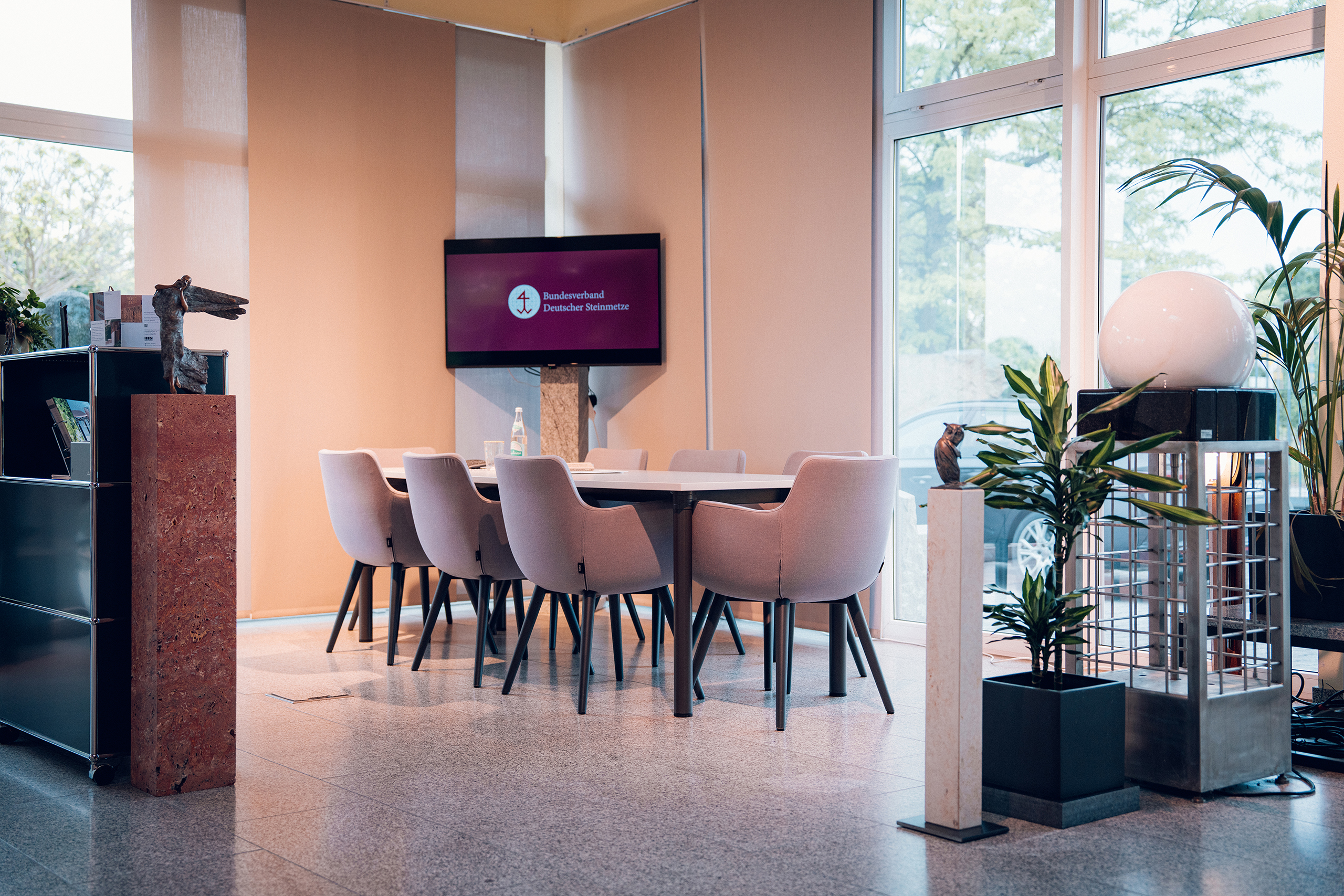 Innenbereich mit Besprechungstisch und Ausstellungsstücken im Showroom