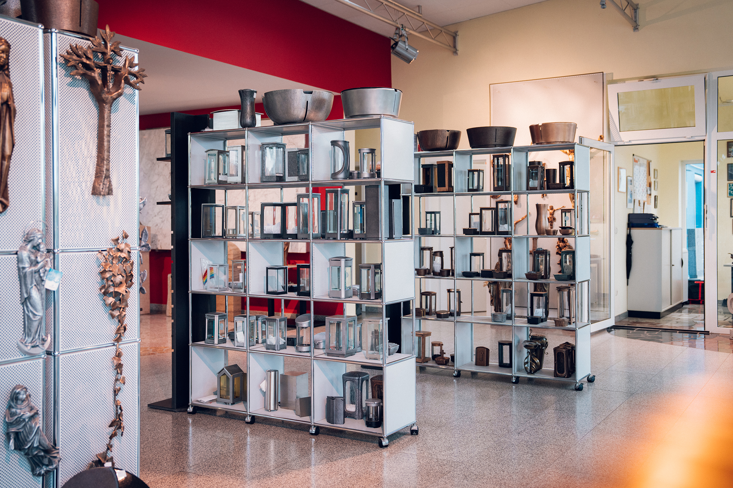 Ausstellungsraum mit Grablaternen, Vasen und Wandkreuzen