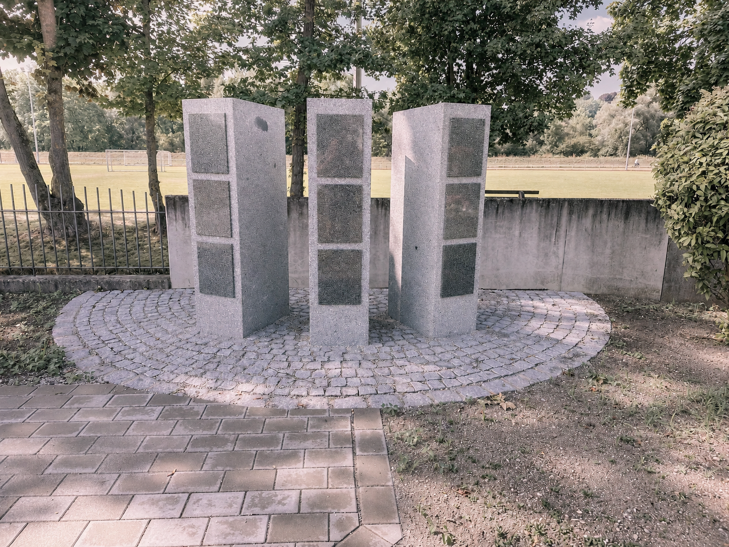 Drei Granit-Stelen mit Tafeln, halbkreisförmig auf Pflasterboden angeordnet