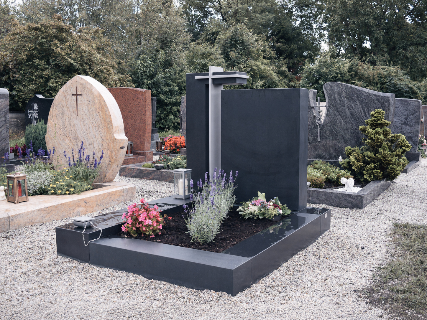 Modernes dunkles Granit-Grabmal mit Kreuz und bunter Grabbepflanzung