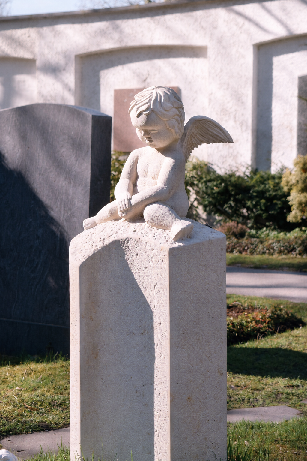 Steinskulptur eines Engels als Grabschmuck auf einem Friedhof