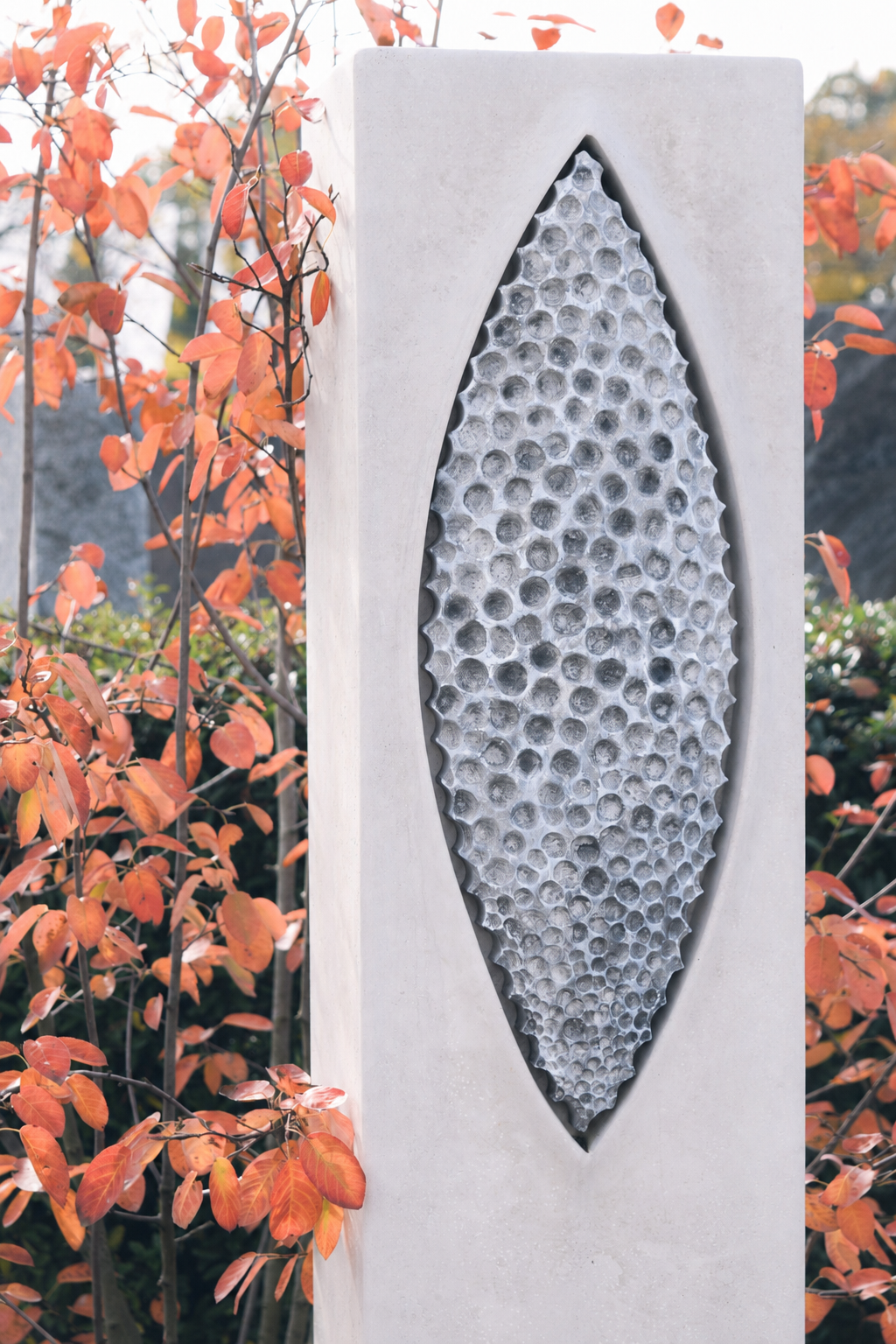 Helle Stele mit blattförmigem Relief in Wabenstruktur